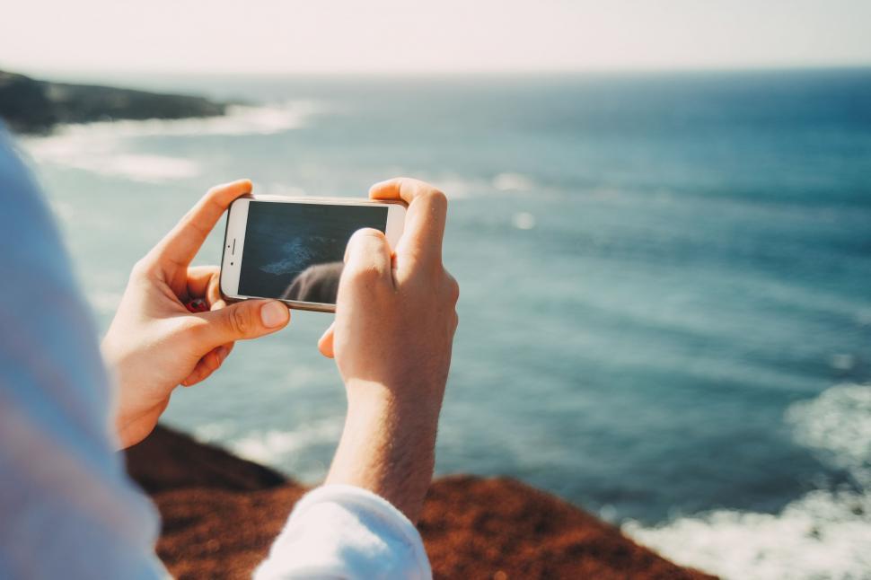 Person Taking A Picture Of The Ocean With A Cell Phone